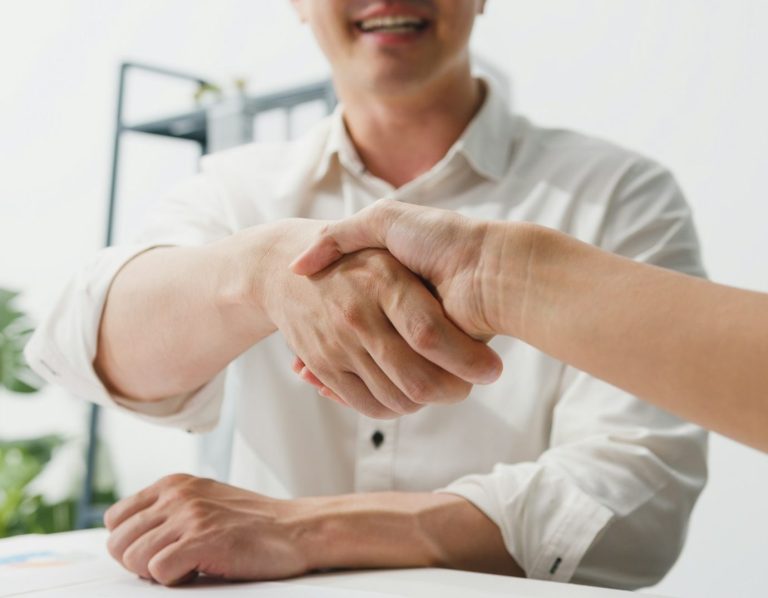 The team go thought a quote for a home owner Two people shaking hands in a business setting.