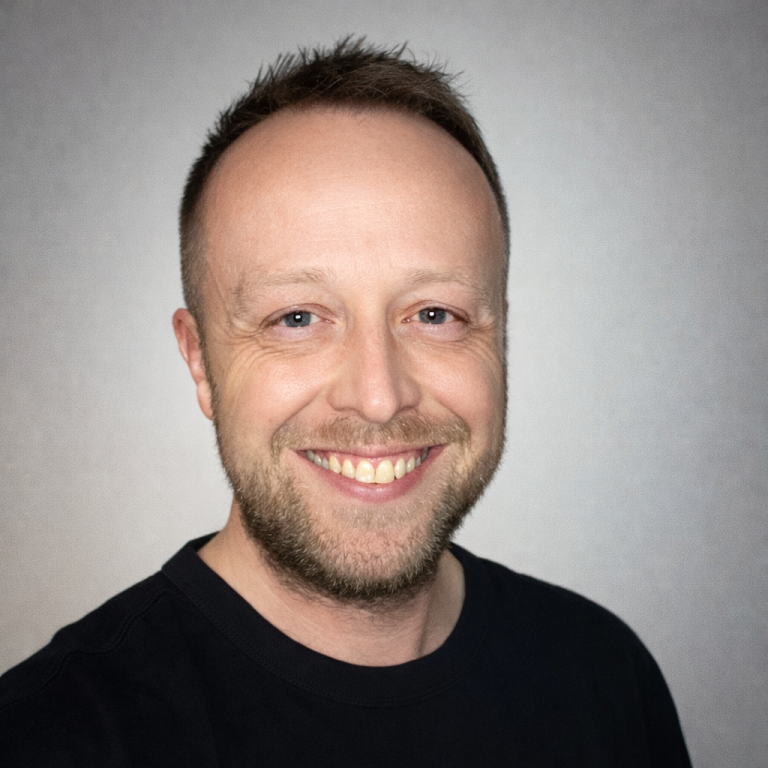 Aron Jarvis, the founder Aron Jarvis, the founder, with short, light hair wearing a black shirt against a grey background.